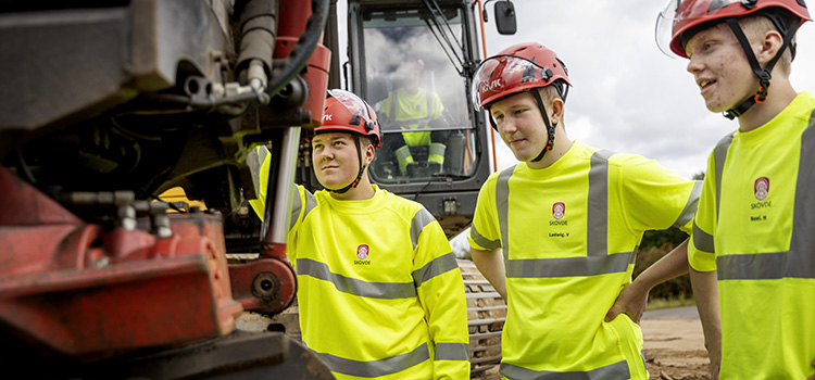 Bild på elever och en grävskopa.